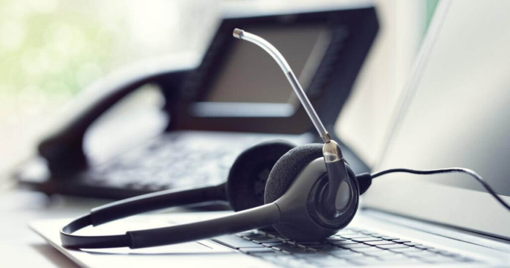 closeup of a call center rep headset resting on top of a laptop keyboard