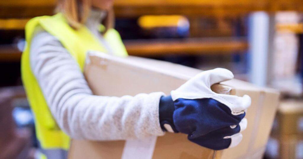 close up of female warehouse worker carrying a box