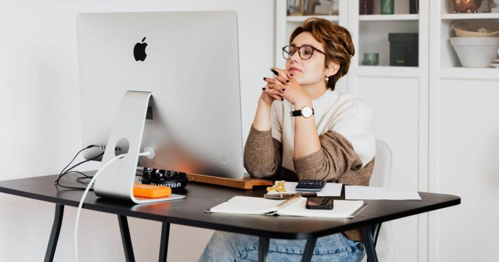 HR manager at a desktop computer reviewing employee performance data, representing responsible AI use in workforce monitoring and engagement